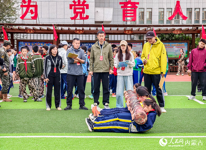 呼和浩特市玉泉区首届青少年国防教育军事体育技能大赛现场，小选手进行抱圆木仰卧起坐项目比拼。丁根厚摄