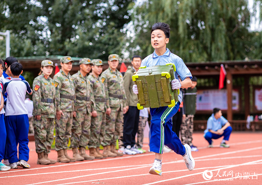 呼和浩特市玉泉区首届青少年国防教育军事体育技能大赛现场，小选手在进行接力搬运弹药箱项目的比拼。丁根厚摄