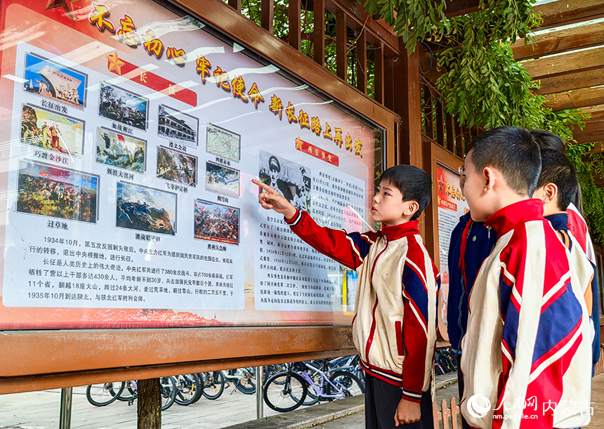 呼和浩特市玉泉区首届青少年国防教育军事体育技能大赛现场，小选手在国防教育文化长廊了解红军长征历史。丁根厚摄
