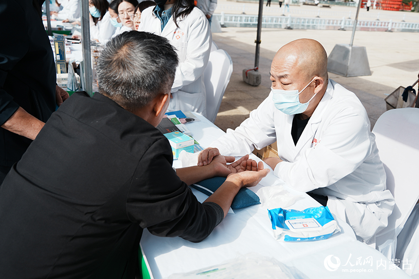 醫務人員為老年群眾把脈問診，提供健康咨詢服務。實習生 徐振宇攝