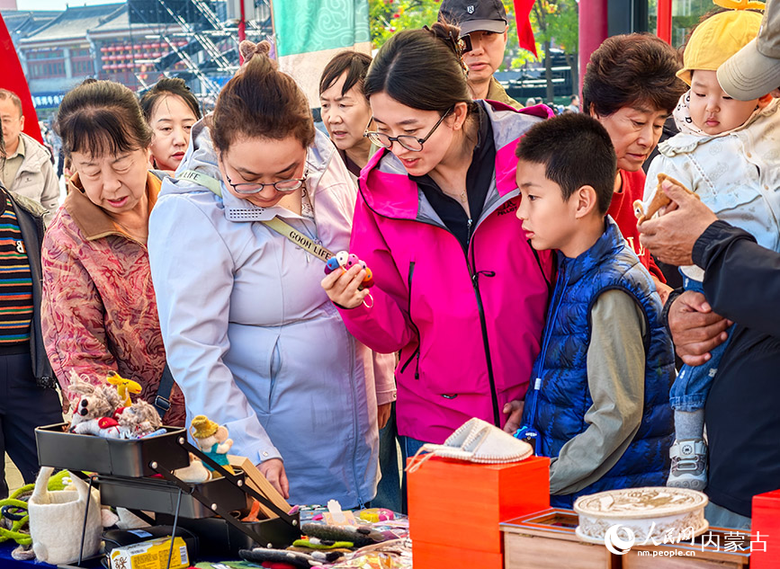 10月2日，游客在呼和浩特市玉泉區塞上老街的內蒙古守藝對外交流市集挑選民族風文創產品。丁根厚攝