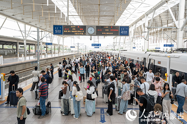旅客正在站台排队乘车。杨颐摄