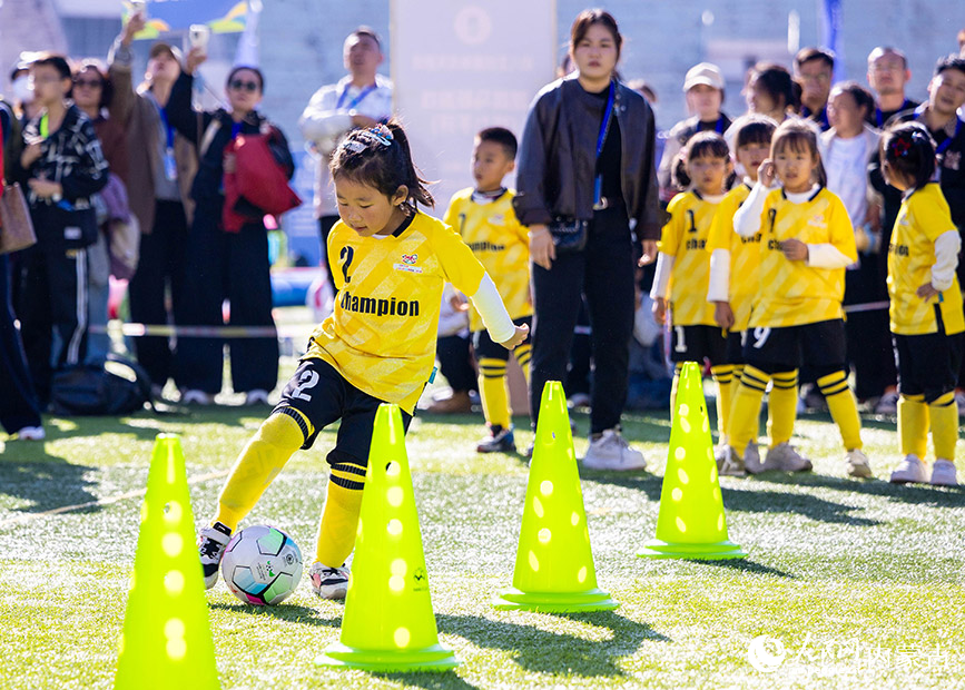 10月11日，呼和浩特市幼儿足球嘉年华暨低年龄段校园足球比赛现场，孩子们在参与运球闯关比赛。丁根厚摄
