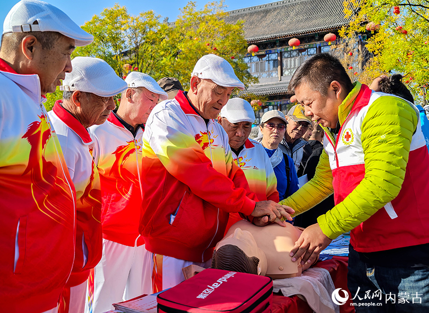 呼和浩特市玉泉區“我們的節日·重陽”主題活動現場，紅十字會工作人員在指導老年人學習心肺復蘇急救技能。丁根厚攝