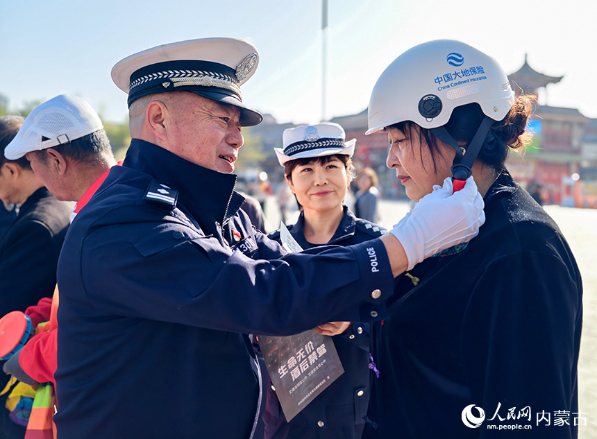 呼和浩特市玉泉區“我們的節日·重陽”主題活動現場，交警向市民普及安全頭盔佩戴知識。丁根厚攝