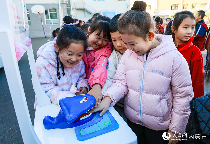 呼和浩特市玉泉區石東路小學校園科學節活動現場，學生在體驗反應測試科普裝置。丁根厚攝