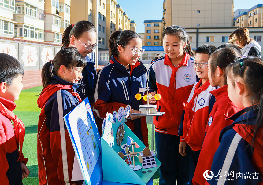 呼和浩特市玉泉區石東路小學校園科學節活動現場，學生向同學們介紹自制的小小氣象站科創作品。丁根厚攝