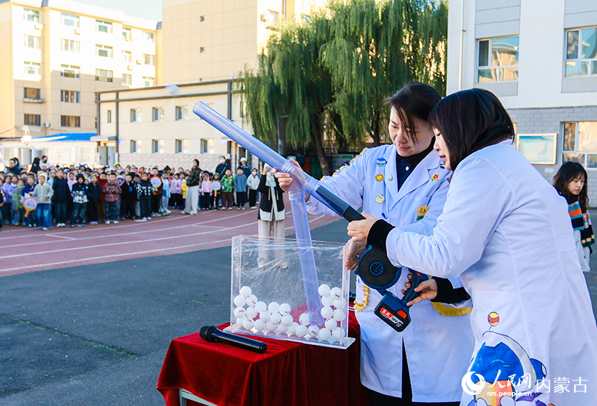 呼和浩特市玉泉區石東路小學校園科學節活動現場，工作人員為學生們演示趣味科學實驗。丁根厚攝
