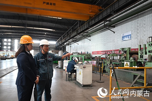 包頭威豐新材料有限公司生產主任賈建鋒（左二）正在給工商銀行內蒙古包頭稀土高新技術產業開發區支行工作人員介紹生產流程。人民網記者 劉藝琳攝