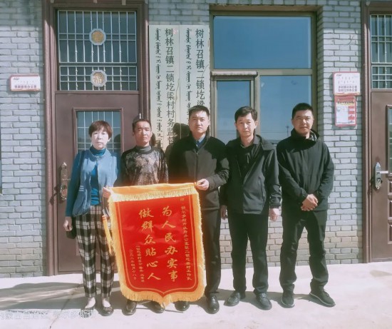 鲁杰和妻子乌秀琴给驻村工作队送来锦旗。